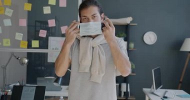 Salgın sırasında tıbbi maske takan genç girişimcinin yavaş çekim portresi