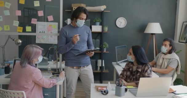 Un Arabe sérieux s'entretient avec des collègues au bureau pour discuter d'un projet de remue-méninges — Video