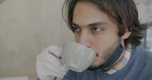 Retrato de cerca del guapo tipo de Oriente Medio tomando café en la cafetería durante la pandemia — Vídeo de stock