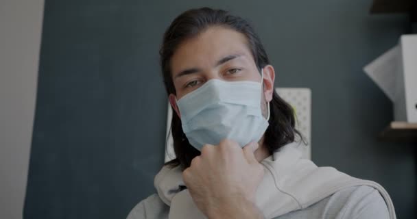 Portret młodego biznesmena w masce medycznej rozmawiającego przez telefon wideo w biurze — Wideo stockowe