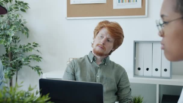 Attraktiva unga affärsman flygande papper flygplan sitter på tråkiga affärsmöte på kontoret — Stockvideo