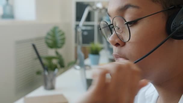Close-up of female face call center worker talking to client with headset microphone — Stock Video