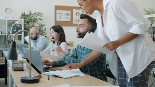 Grupo de personas llaman a operadores de centros firmando papeles que las mujeres afroamericanas traen a los trabajadores — Vídeos de Stock