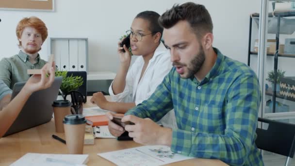 Verveelde medewerkers bezig met casual stuff tijdens vergadering op het werk spelen games en het opzetten van make-up — Stockvideo