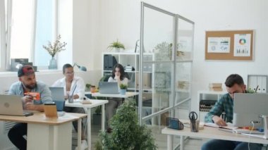 Meslektaşlar, genç erkekler ve kadınlar oyuncak silahların keyfini çıkarırken ofiste gülüp eğleniyorlar.