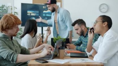 Sebepsiz çalışanlar iş toplantısını görmezden geliyor ve patron cep telefonlarıyla sohbet ediyor ve oyunlar oynuyor.