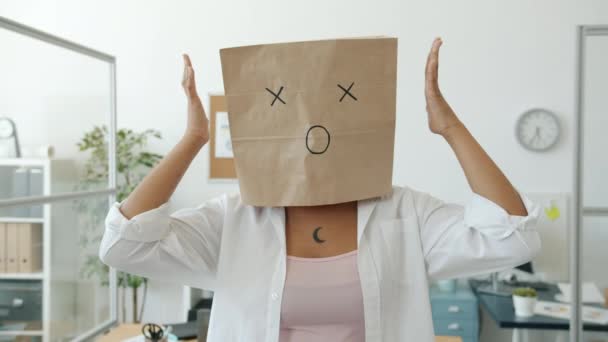 Retrato de mulher com máscara de saco de pão mostrando expressão chocada gestos de pé no escritório — Vídeo de Stock