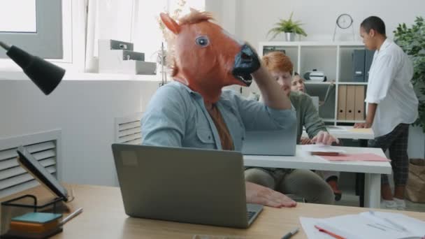 Wütender Geschäftsmann mit Pferdemaske telefoniert und gestikuliert am Schreibtisch im Büro — Stockvideo