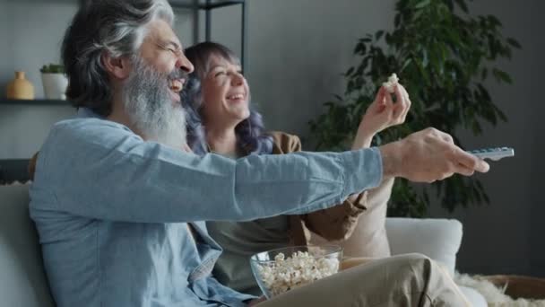 Lachende Menschen Familie vor dem Fernseher Popcorn essen und lachen genießen Freizeit in der Wohnung — Stockvideo