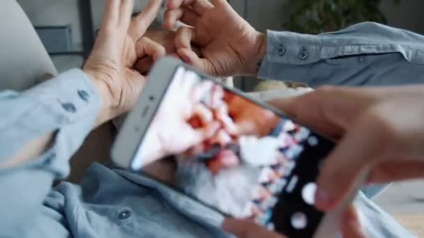 Detailní záběr ženské ruce pomocí smartphonu fotit legrační zralý muž pózuje s legrační tváře — Stock video