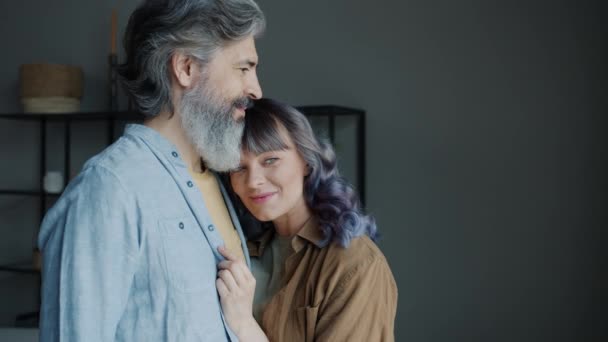 Slow motion portret van volwassen man en jonge vrouw knuffelen staan binnen in appartement — Stockvideo