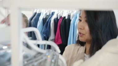 Dükkanda kıyafet seçen genç bayanların gülüşleri.