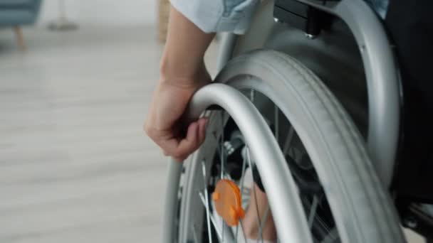 Close-up slow motion of womans hand moving wheelchair indoors at home — Stock Video