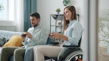 Mutlu çift erkeği ve engelli kız video oyunu oynuyorlar ve evde beşlik çakıyorlar.