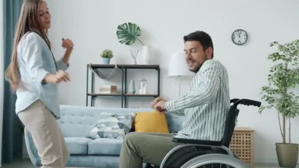 Gyönyörű pár fogyatékkal élő férfi és egészséges nő tánc szórakozás otthon — Stock videók