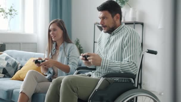 Slow motion of physically impaired man playing video game with cheerful wife then doing high-five — Stock Video