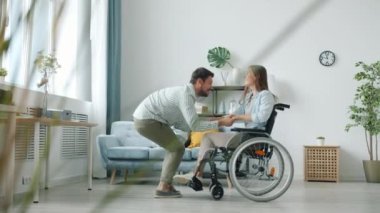 Tekerlekli sandalyede engelli karısıyla dans eden neşeli adam müziğin ve boş zamanların tadını çıkarıyor.