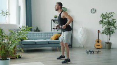 Spor giyim antrenmanında bantlı yakışıklı genç adam yavaş hareket ediyor.