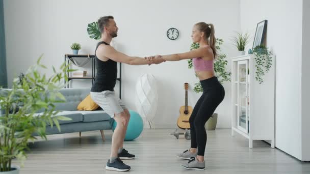 Langzame beweging van man en vrouw hand in hand en kraken uit te werken binnen in modern appartement — Stockvideo