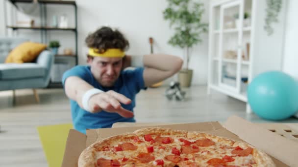 Portré vicces férfi sportoló csinál ropogós majd eszik pizza élvezi gyorsétterem — Stock videók