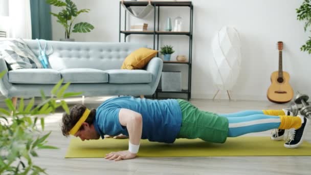 Zpomalení pohybu motivované chlap trénink dělá sportovní cvičení pocit vyčerpání uvnitř bytu — Stock video