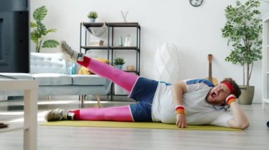 Tembel adamın spor yaparken spor paspası üzerinde antrenman yapması sonra da esneyip uyuması.