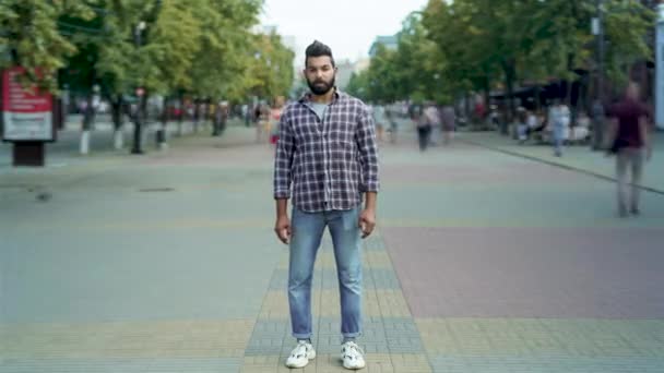 Retrato de lapso de tiempo del atractivo hombre árabe parado afuera en una calle llena de gente mirando a la cámara — Vídeos de Stock