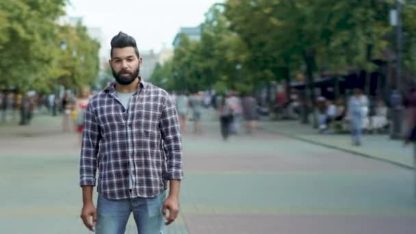 Retrato de lapso de tiempo del hombre árabe confiado de pie en una calle concurrida con jóvenes caminando — Vídeo de stock