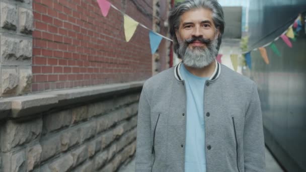 Portret van tevreden volwassen man tonen OK hand gebaar buiten in de stad glimlachen — Stockvideo