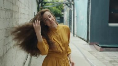 Dışarıda dans eden kaygısız kızın yavaş yavaş gülümsemesi.