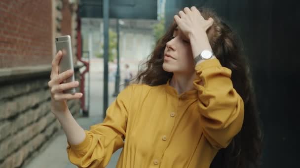 Movimento lento de bela jovem senhora tomando selfie usando câmera de smartphone na rua — Vídeo de Stock
