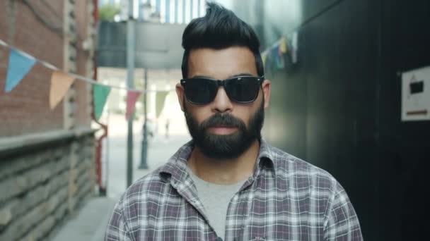 Zpomalený portrét stylového Araba, který nosí moderní sluneční brýle a stojí venku — Stock video