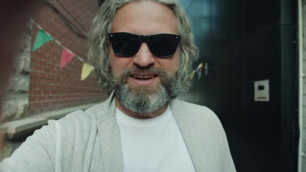 Portret van volwassen man maken van video bellen buiten praten en gebaren wijzen naar de stad straat — Stockvideo