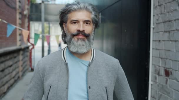 Portret van een vrolijke volwassen man in de stad straat lachend lachend kijkend naar de camera — Stockvideo