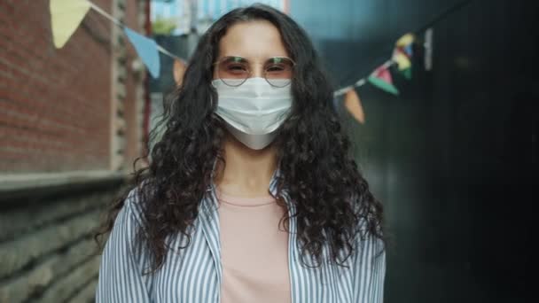 Slow motion portret van jonge Aziatische dame dragen medische gezichtsmasker staan buiten alleen — Stockvideo