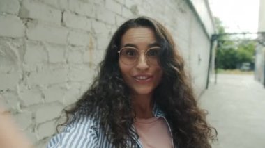 Mutlu Asyalı kız portresi çevrimiçi video çekiyor sohbet ediyor ve el sallıyor.