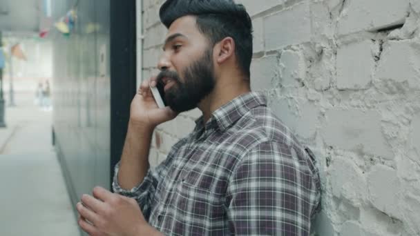 Zpomalený portrét radostného Araba mluvícího na mobilním telefonu stojící venku ve městě — Stock video