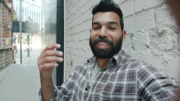 POV retrato de belo homem árabe falando e acenando mão olhando para câmera fazendo chamada de vídeo na rua — Vídeo de Stock