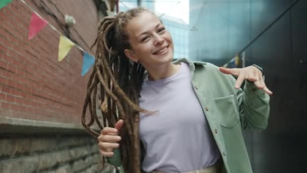 Opgewonden jonge vrouw met creatieve dreads dansen buiten glimlachen genieten van muziek en vrije tijd — Stockvideo