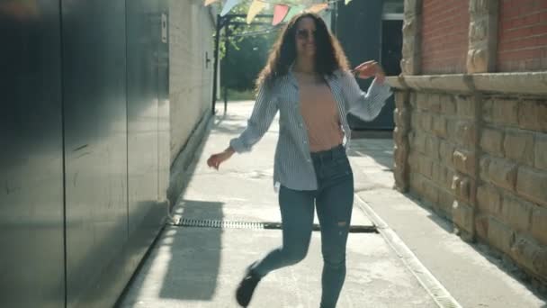 Ritratto al rallentatore di attraente donna moderna che danza all'aperto in strada nella soleggiata giornata estiva — Video Stock