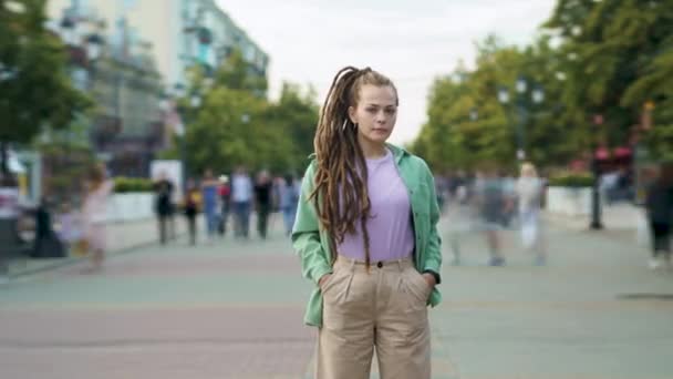 Time lapse of confident young woman with dreads standing outdoors alone in urban street — Stock Video