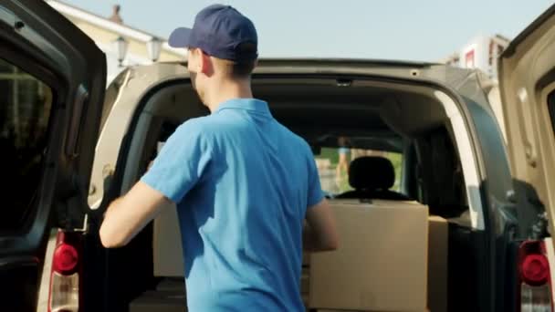 Retrato del repartidor tomando la caja de cartón de la furgoneta y llevándola a la casa de los clientes — Vídeos de Stock