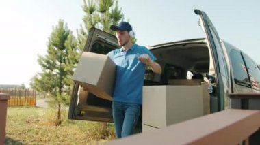 Neşeli teslimatçı kulaklıkla müzik dinlemekten ve evden eve paket taşımaktan hoşlanır.