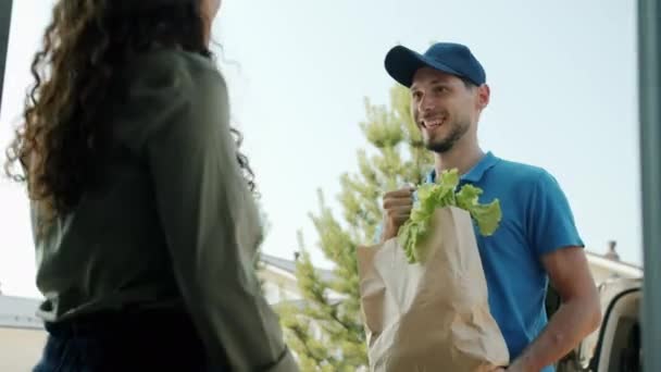 Kundin bekommt Bio-Lebensmittel von männlichem Kurier und bezahlt mit Smartphone — Stockvideo