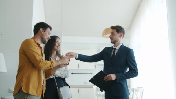 Mouvement lent de la maison d'achat de famille obtenir des clés de l'agent immobilier étreignant à l'intérieur — Video