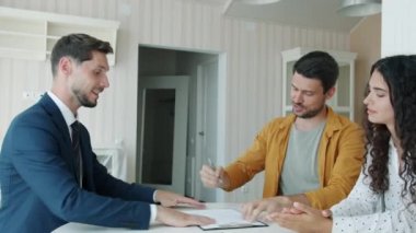 Neşeli adam satış ve alım anlaşmasını imzalarken broker 'ın el sıkışan karısından anahtarları alıyor.