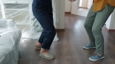 Genç insanlar yeni evde dans edip taşınmayı kutluyorlar.