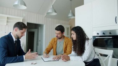 Konut sözleşmesi imzalayan adam emlakçıdan anahtar alıyor.