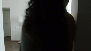 Takım elbiseli mutlu bir emlakçı, birkaç alıcıya yeni evi gösteriyor.