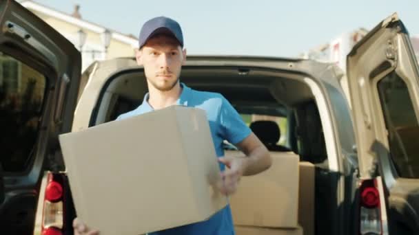 Schuss auf Zusteller, der Paket aus Lieferwagen trägt und dann an Haustür klopft — Stockvideo